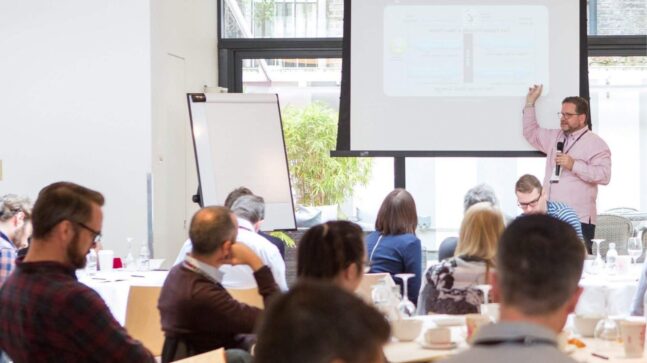 Image of Bob Moesta in front of a room full of students teaching Jobs to be Done in business school